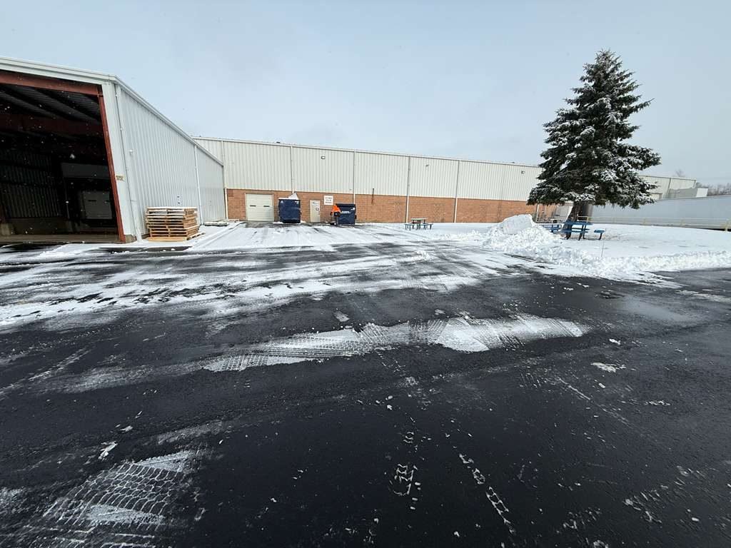 Business park parking lot plowed clear beside a warehouse