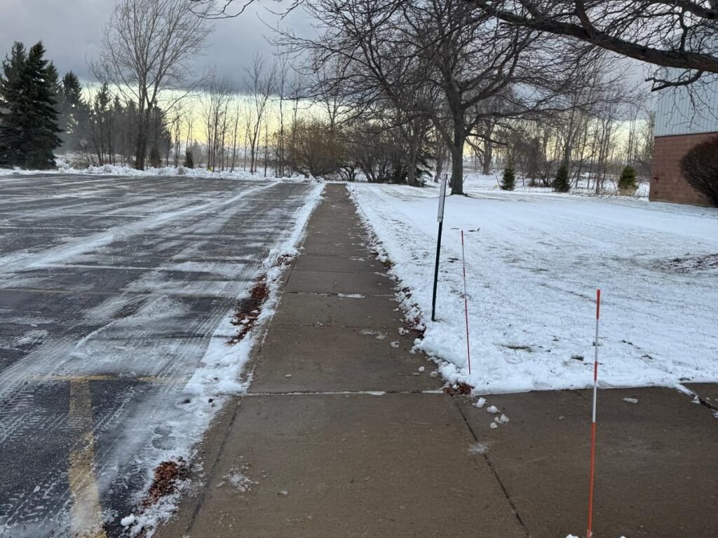 Business park sidewalk edged clean beside a plowed parking lot