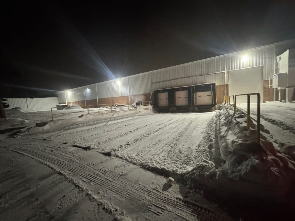 Warehouse loading dock apron cleared at night under floodlights