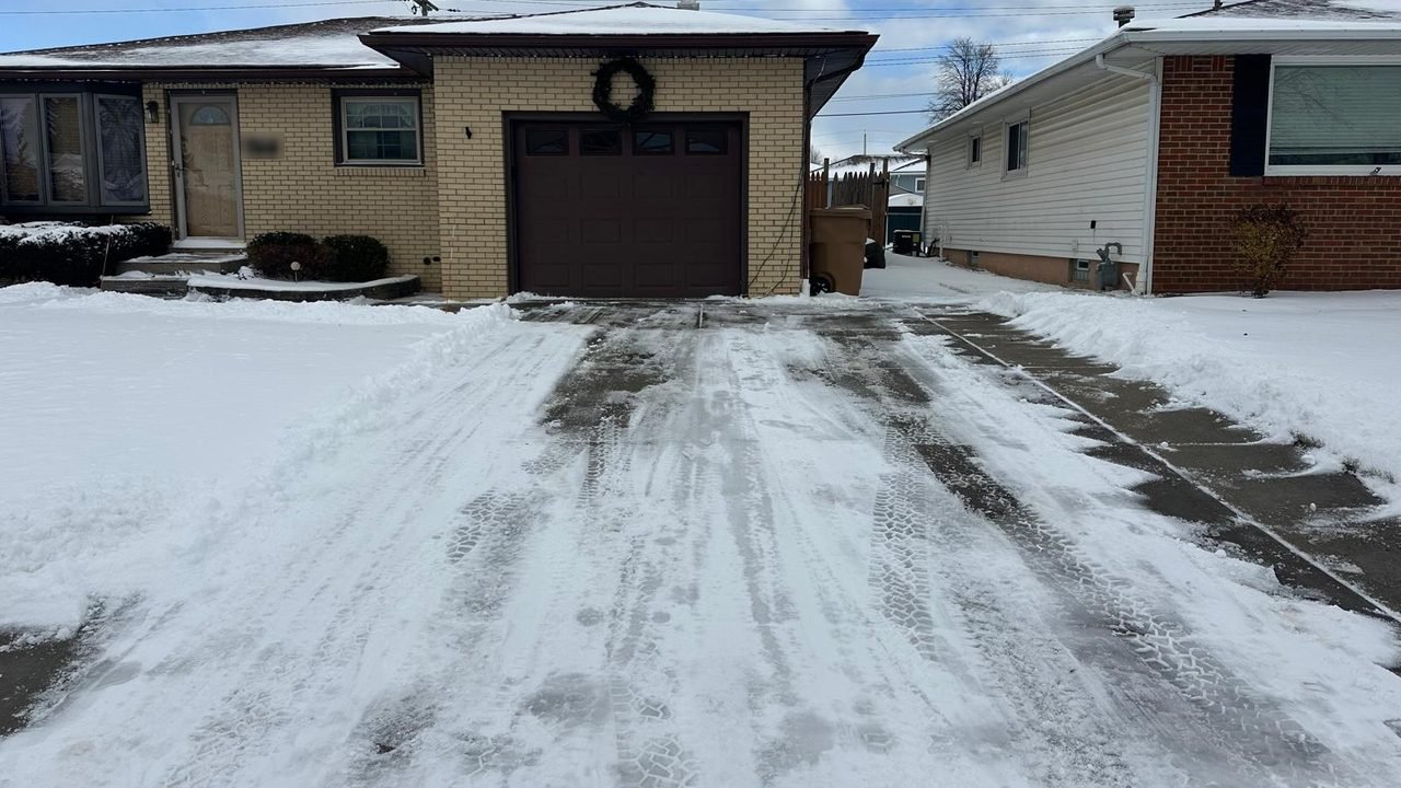 Residential driveway cleared the full width up to the garage after a snowfall